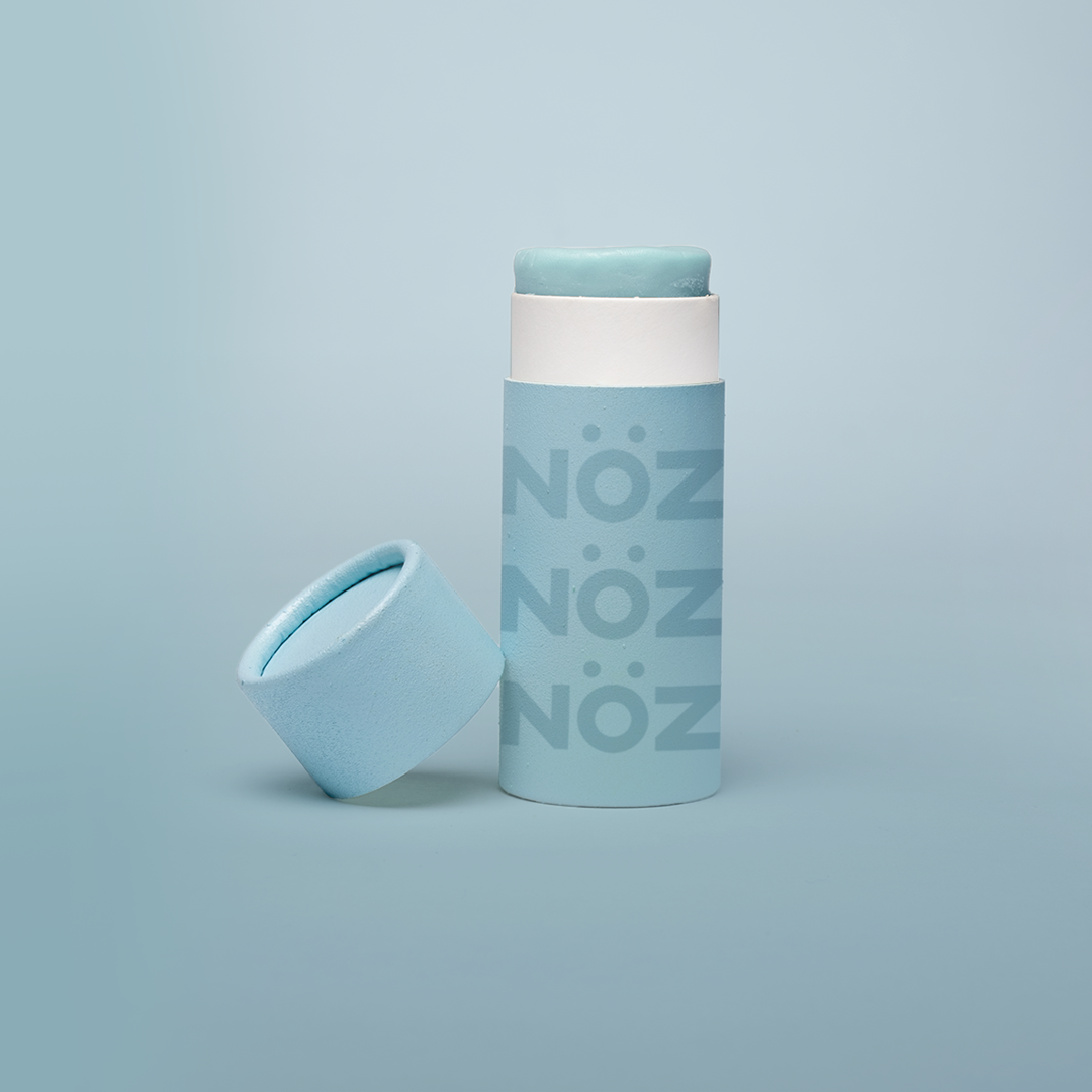 Green Noz sunscreen with lid off and same color background