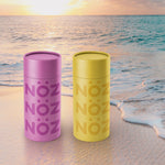 Load image into Gallery viewer, Purple and yellow Noz sunscreen on beach with sunset
